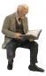 Preview: Reisender mit Buch, Modellbahnfigur sitzend handbemalt, Spur 0 (Null), 1:45